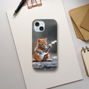 May include: A phone case with a cute orange tabby kitten playing an electric guitar. The kitten is sitting on a gray background.