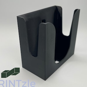 May include: A black, 3D-printed card holder with a rectangular base and curved sides. The holder has a slot on the front and a hole for mounting. The logo "TPRINTzle" is visible in the bottom left corner.