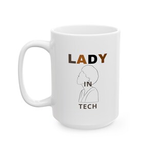 Könnte beinhalten: Weiße Keramiktasse mit einer schwarzen Umrandung eines Frauenkopfes und dem Text "LADY IN TECH" in braunen und schwarzen Buchstaben.