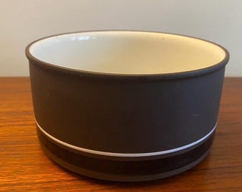 May include: A brown ceramic bowl with a white rim and two black bands around the outside.