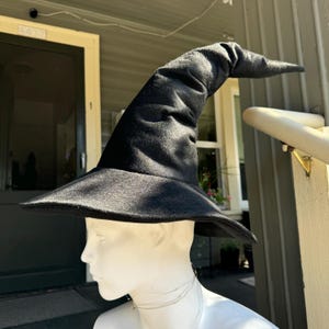 May include: A black felt witch hat with a tall, pointed crown and a wide brim.
