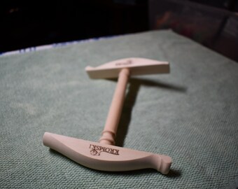 May include: A wooden tool for making yarn, with a handle and two curved pieces. The tool is labeled "KROMSKI".