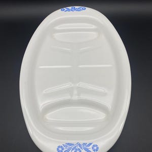 Puede incluir: Plato de servir ovalado blanco con un dise&ntilde;o floral azul alrededor del borde. El plato tiene tres secciones divididas para servir diferentes alimentos.
