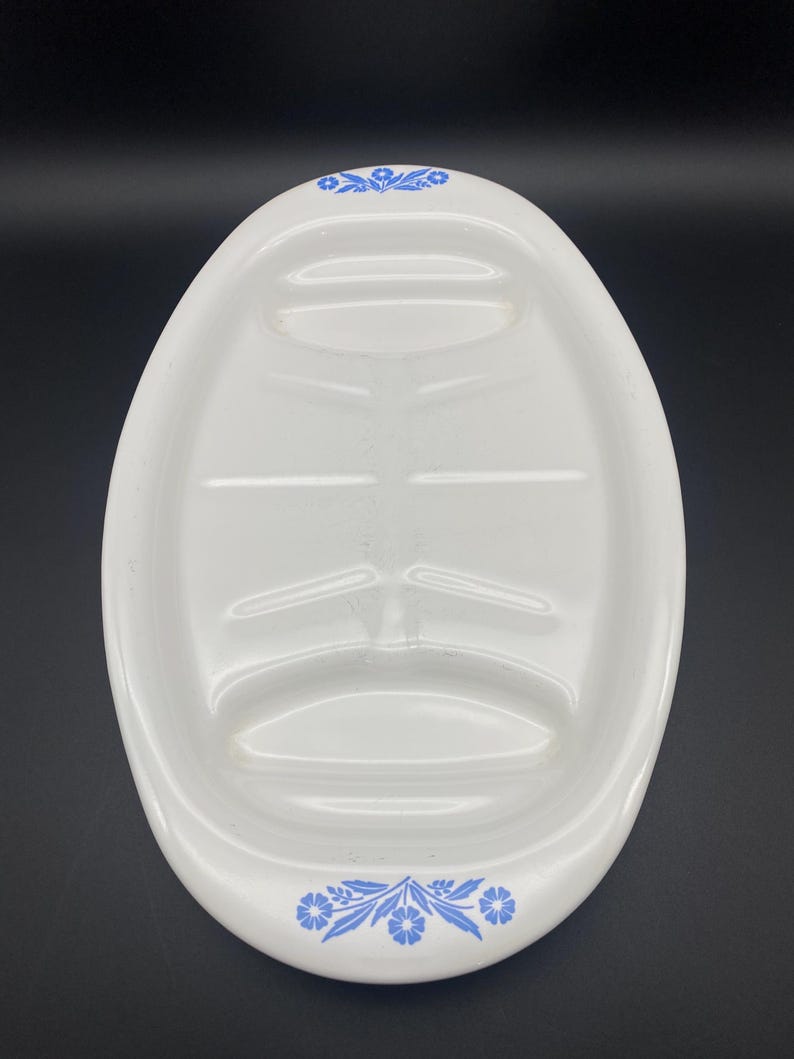 Puede incluir: Plato de servir ovalado blanco con un dise&ntilde;o floral azul alrededor del borde. El plato tiene tres secciones divididas para servir diferentes alimentos.