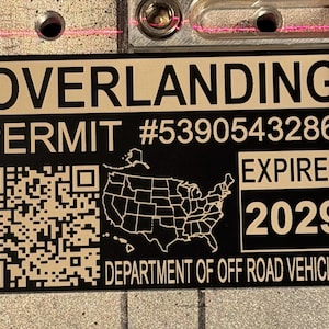 May include: Black and tan permit with the word OVERLANDING at the top. The permit number is #5390543286 and expires in 2029. A QR code and a map of the United States are also on the permit. The bottom of the permit says DEPARTMENT OF OFF ROAD VEHICLES.