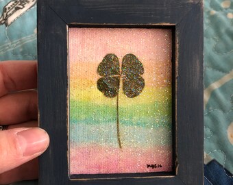 Real four leaf clover framed with rainbow watercolor and glitter