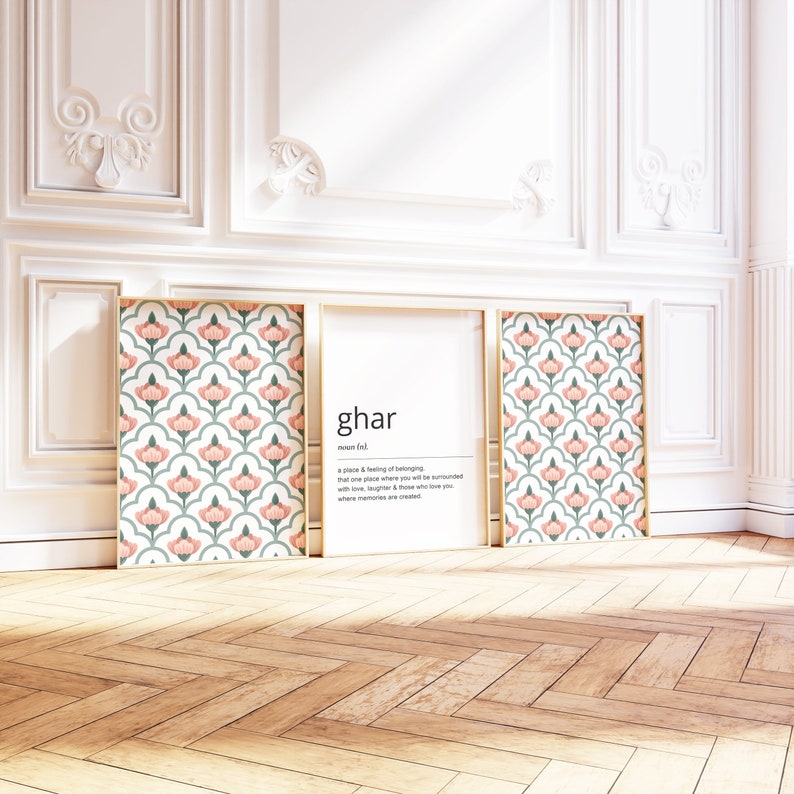 May include: Three framed prints featuring a pink and green floral pattern. The centre print defines the word "ghar" as "a place & feeling of belonging, that one place where you will be surrounded with love, laughter & those who love you, where memories are created."