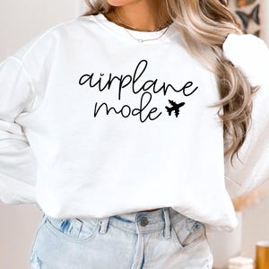 May include: White long-sleeve sweatshirt with the text "airplane mode" and a small airplane graphic.