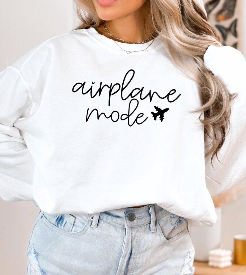 May include: White long-sleeve sweatshirt with the text "airplane mode" and a small airplane graphic.