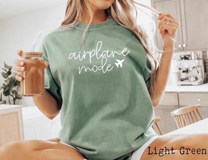 May include: A light green t-shirt with the text "airplane mode" in white lettering and a small airplane graphic.