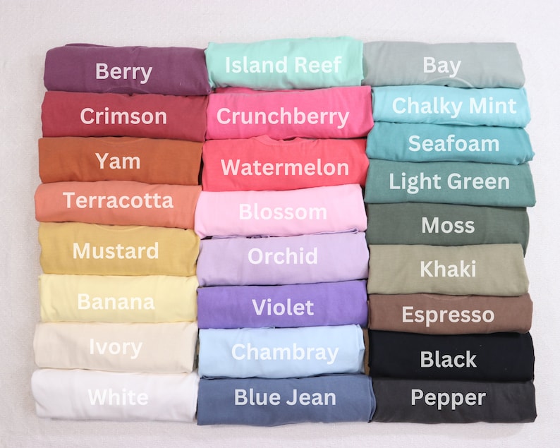 May include: A color chart of 18 different fabric swatches, each folded in half. The swatches are arranged in three columns of six swatches each. The colors include berry, crimson, yam, terracotta, mustard, banana, ivory, white, island reef, crunchberry, watermelon, blossom, orchid, violet, chambray, blue jean, bay, chalky mint, seafoam, light green, moss, khaki, espresso, black, and pepper.