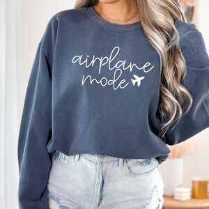 May include: A dark blue sweatshirt with the text "airplane mode" in white lettering and a small airplane graphic.