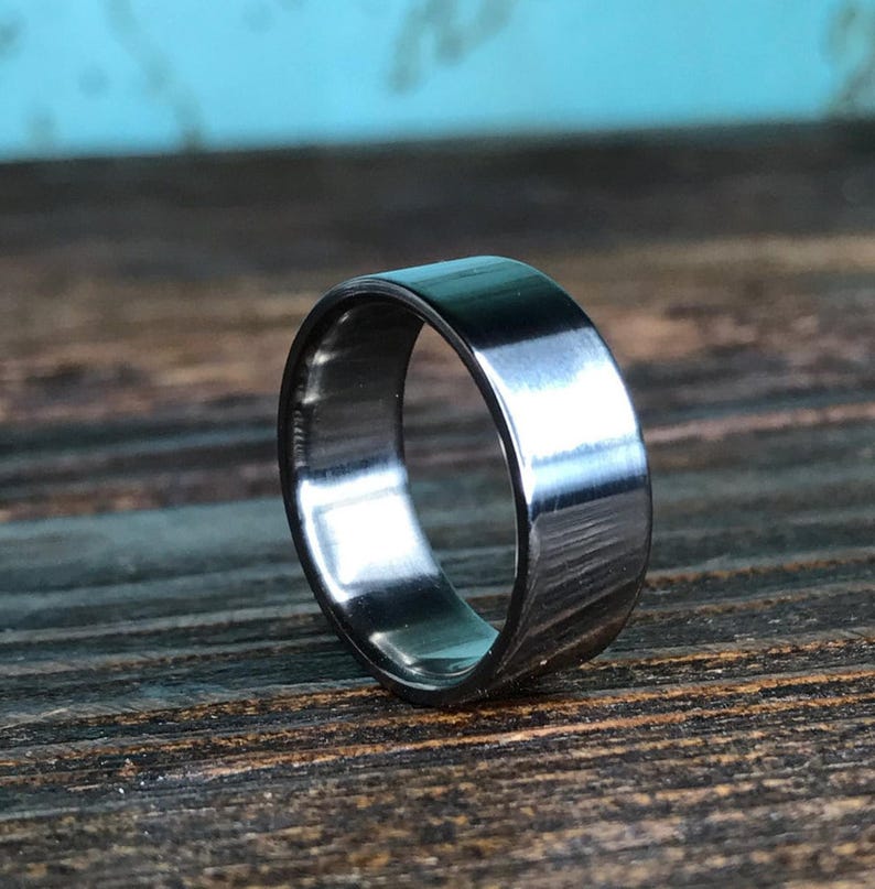 A dark metallic band standing upright on a rustic wooden table.