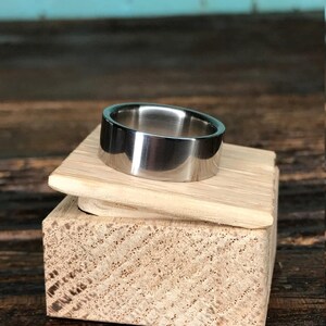 A metallic ring sitting on the lid of a small wooden block.