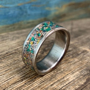 Pu&ograve; includere: Un anello d'argento con una fascia macchiata di verde, arancione e oro.