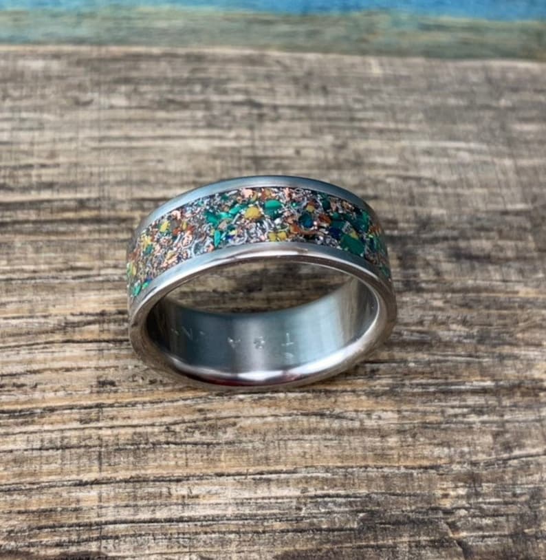 Pu&ograve; includere: Un anello d'argento con una fascia macchiata di verde, marrone e oro.