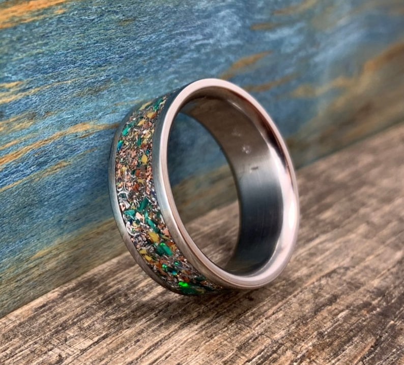 Pu&ograve; includere: Un anello d'argento con una fascia macchiata di verde, oro e marrone.