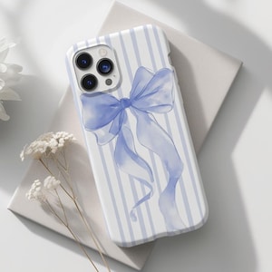 May include: A white phone case with blue and white stripes and a blue watercolor bow.