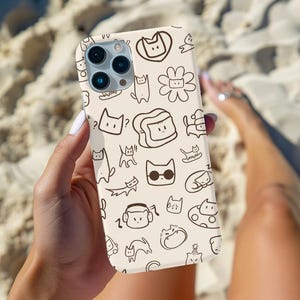 May include: A beige phone case featuring a repeating pattern of whimsical cat illustrations in brown. The cats are depicted in various poses and expressions, including some wearing sunglasses and headphones. The case has a glossy finish.