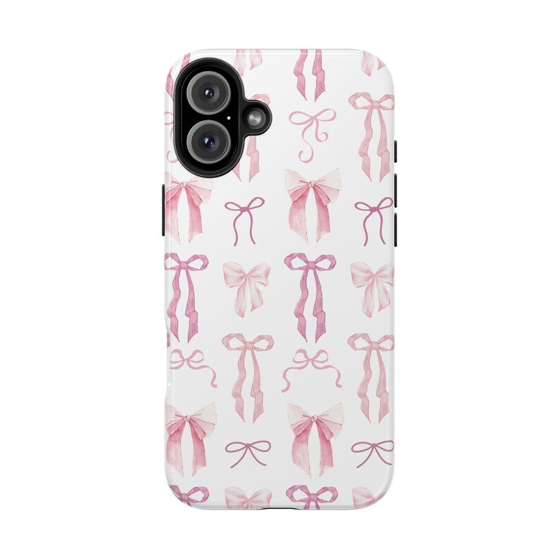 May include: A white phone case with a pink and white watercolor bow pattern. The case has a cutout for the camera lens.