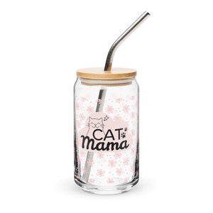 Può includere: Un bicchiere di vetro con un motivo floreale rosa e bianco e il testo "CAT Mama" in nero. Il bicchiere ha un coperchio in bambù e viene fornito con una cannuccia in acciaio inossidabile.
