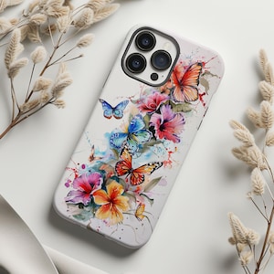 May include: A white phone case with a watercolor design of colorful butterflies and flowers. The case has a cutout for the phone's camera.