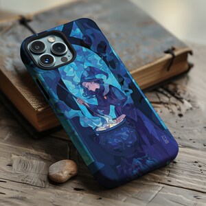 Puede incluir: Una funda de teléfono azul y morado con un diseño de vitral de una bruja revolviendo un caldero. La bruja lleva un sombrero azul y un vestido morado. La funda tiene un recorte para la cámara del teléfono.