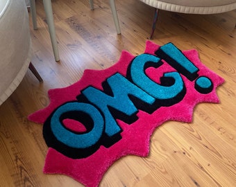 May include: A pink and blue rug with the word "OMG!" in a comic book style font.