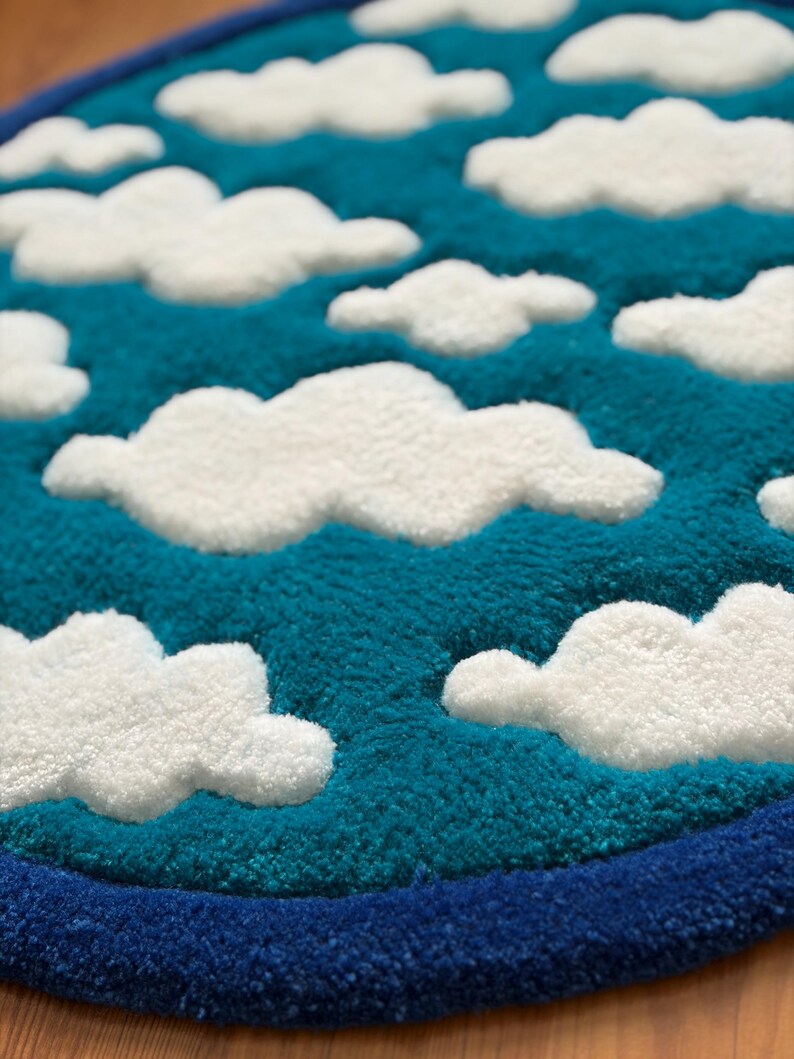 May include: A round rug with a sky and cloud design. The rug features a teal blue background with white, fluffy cloud shapes. A dark blue border frames the design.