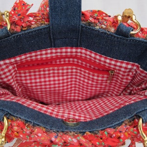 May include: A denim tote bag with a red and white gingham lining. The bag has a zippered pocket on the inside and two wooden handles.