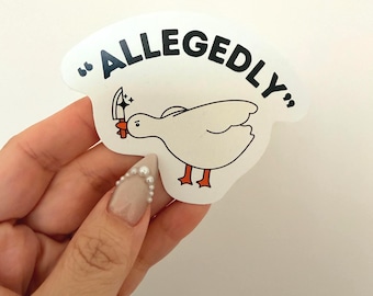 Pode incluir: Um autocolante branco com um pato de desenho animado segurando uma faca, com a palavra "ALLEGEDLY" em texto preto acima. O pato tem pés e bico laranja. O autocolante é segurado por uma mão com uma unha decorada.