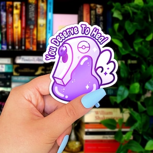 May include: Purple and white sticker with a cartoon character and the text "You Deserve To Heal!"