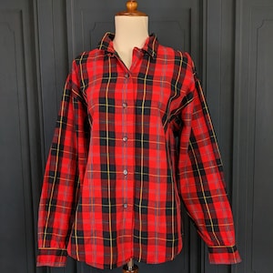 May include: A red, black and yellow plaid button-up shirt with long sleeves.