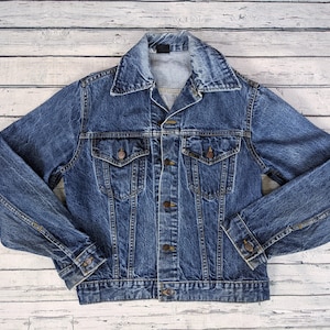 May include: A classic blue denim jacket with a button-up front, two chest pockets, and long sleeves.