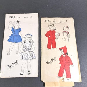 May include: Two vintage sewing patterns for children's clothing. The pattern on the left is for a dress with a ruffled collar and is numbered 1928. The pattern on the right is for a red jumpsuit and a red hooded jacket and is numbered 1823.