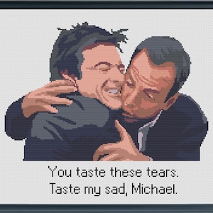 May include: A cross-stitch pattern depicting a scene from the TV show "The Office." Two characters, Michael and Jim, are hugging. The text reads "You taste these tears. Taste my sad, Michael."