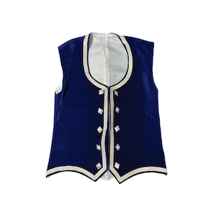 Puede incluir: Un chaleco sin mangas de terciopelo azul marino con ribetes blancos y detalles en forma de diamante. El chaleco tiene un escote redondo y una parte delantera abotonada. El forro interior es blanco.
