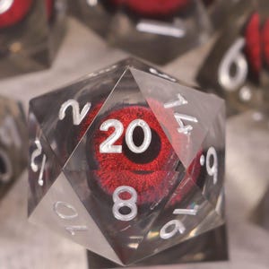 Op de afbeelding: Set van zeven polyhedrale dobbelstenen met een helder, facetachtig ontwerp. Elke dobbelsteen heeft een rode, getextureerde kern met witte cijfers. De dobbelstenen zijn ontworpen voor tabletop-rollenspellen.