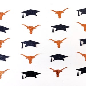May include: Glittery orange longhorn and black graduation cap confetti scattered on a white background. The confetti is designed for graduation celebrations, with a focus on school spirit and academic achievement. The image is suitable for crafting or party decorations.
