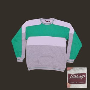 May include: A vintage color block sweatshirt with green, white, and gray horizontal stripes. The long sleeves are green, and the neckline and cuffs are trimmed in green. The tag reads "line-up" and "Made in Taiwan."