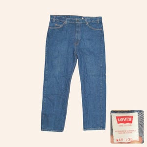 May include: Blue denim jeans with a classic five-pocket design. The jeans have a straight leg cut and a button and zipper closure. The Levi's label is visible, indicating 100% cotton. The waist size is W40 and the inseam is L30.
