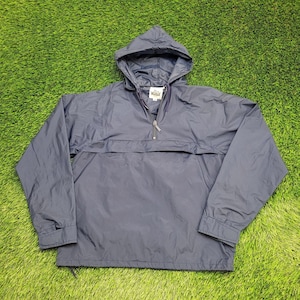 May include: Navy blue hooded anorak jacket with a half-zip closure. The jacket features a front pocket and a drawstring at the hem. The hood is attached and the sleeves have elastic cuffs. The jacket is made of a lightweight, water-resistant material.