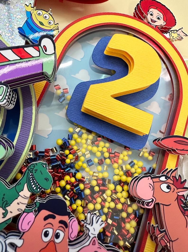 Puede incluir: Decoraci&oacute;n colorida y en capas con personajes de la pel&iacute;cula Toy Story. El dise&ntilde;o incluye un gran n&uacute;mero 2 amarillo, un arco iris y recortes de personajes, con acentos amarillos, rojos y azules. El fondo tiene un patr&oacute;n de cielo y nubes.