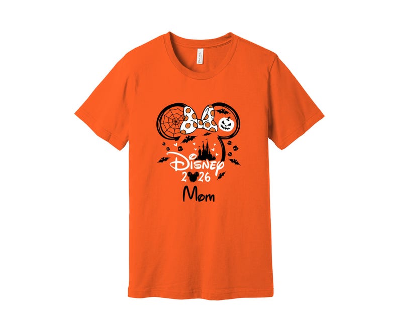May include: Orange t-shirt with a Disney Halloween design. The design includes Mickey Mouse ears, a bow, a castle silhouette, bats, and the text "Disney 2026 Mom."