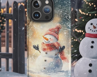 May include: A phone case featuring a winter scene with a snowman wearing a red hat and scarf. The case is displayed on a wooden stand, with a snowy background, a Christmas tree, and a fence.