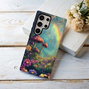 May include: A phone case with a colorful illustration of mushrooms, flowers, and a rainbow. The case has a cutout for the phone's camera.