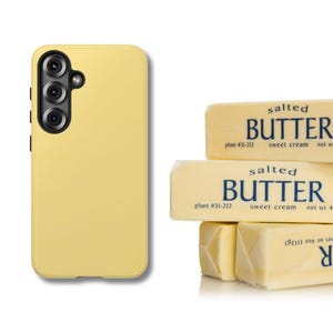 May include: A yellow phone case with a triple-lens camera is next to a stack of salted butter sticks. The butter packaging reads "salted butter, sweet cream, net wt 4 oz (113g)".