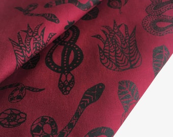 Bandana com estampa de cobra em tons de vinho e preto.