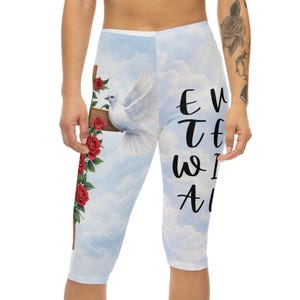 Könnte beinhalten: Capri-Leggings mit hellblauem Hintergrund, auf dem eine weiße Taube, ein Holzkreuz mit roten Rosen und der Text "Every Time We All" abgebildet sind. Die Leggings haben eine verkürzte Länge.