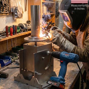 May include: A blue and black Bosch 18V cordless drill positioned next to a metal welding project. A welder wearing a protective helmet and gloves uses a torch to join a metal pipe to a circular flange on a steel base, creating bright sparks.